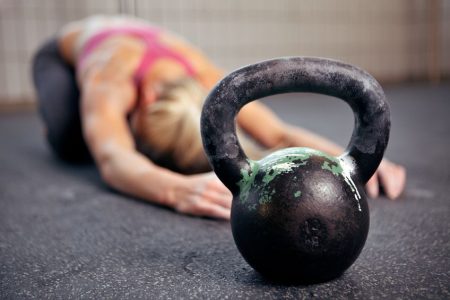 female stretching with kettlebelll