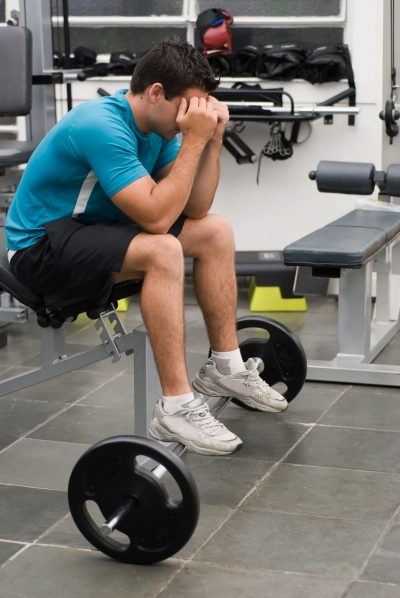 7 Bad Habits for Personal Fitness Trainers 17 Man with head down in weight room