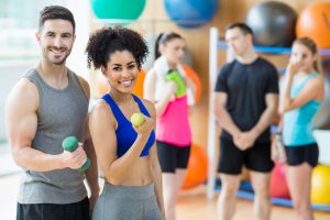 Client And Trainer Smiling At Camera At The Gym