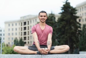 Portrait Of Young Men Doing Butterfly Yoga Pose Outdoors