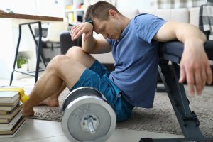 Tired From Sports Exercises Guy Sits Floor At Home